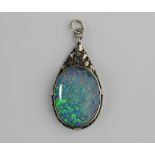 An opal single stone pendant the silver and silver gilt setting with foliate decoration in an Arts