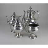 A Continental white metal four piece tea and coffee set baluster form cast with vine leaves and