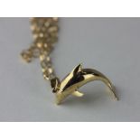 A 9ct gold pendant designed as a dolphin, with a 9ct gold oval link neck chain on a bolt ring