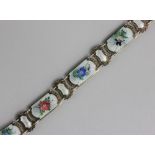 An enamelled and gilt bracelet the shaped rectangular links enamelled with differing flowers, on a