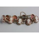 A gold and shell cameo bracelet the oval links carved as the portraits of ladies, on a snap clasp
