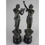 A pair of spelter figures of a female playing a harp, and another with castanets 42cm high including