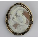 A gold mounted oval shell cameo brooch carved with a classical female figure feeding a bird of