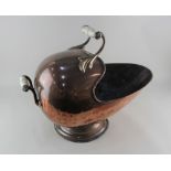 A copper coal scuttle of helmet shaped form with ceramic handles