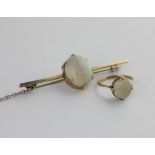 A gold bar brooch claw set with an oval opal detailed 9ct, with s gold ring claw with an opal