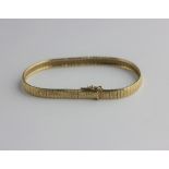 A gold bracelet decorated with a textured finish, on a snap clasp detailed 18 0,750, length 18.