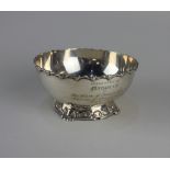 An Indian silver circular bowl with cast scroll border and base, presentation inscription dated