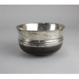 A George V silver mounted circular wooden bowl Elizabethan style with engraved pattern rim, maker