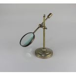 A brass magnifying glass on adjustable stand stand 27cm high