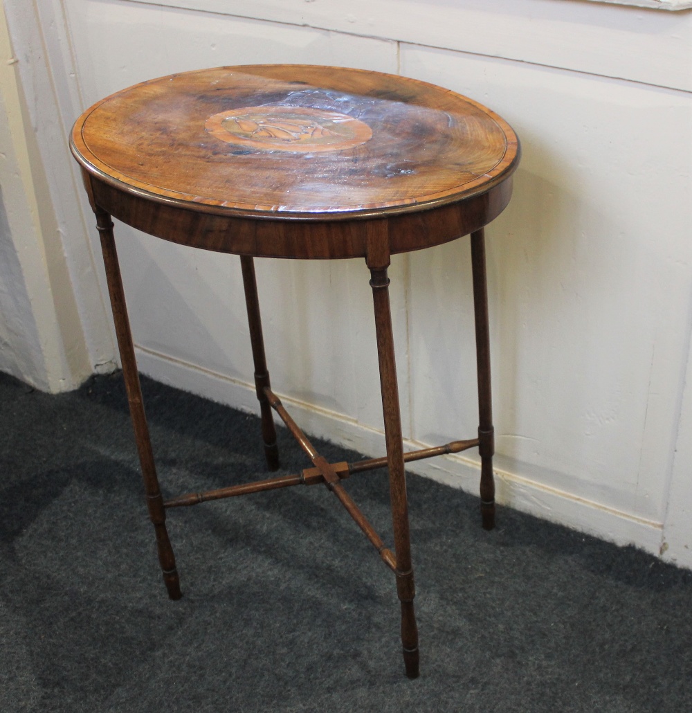 An Edwardian mahogany inlaid occasional table, the crossbanded oval top with central shell motif, on