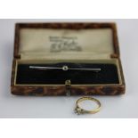 A gold and diamond single stone bar brooch collet set with a cushion shaped diamond and a gold and