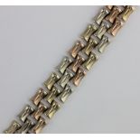 A 9ct three colour gold bracelet in a bamboo form design, having a textured finish, on a snap clasp,