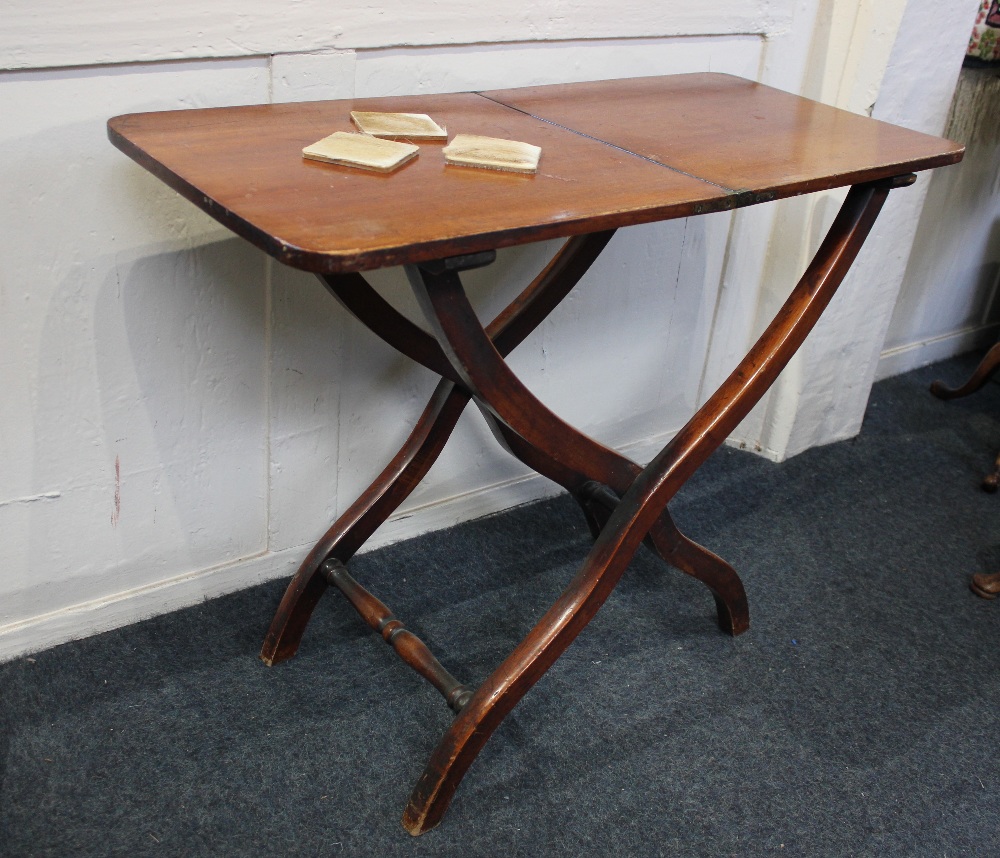 A 19th century mahogany coaching table, the folding rectangular top with rounded corners, on