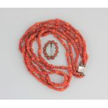 A three row necklace of coral beads (one or two replacement beads, with a gold and coral brooch of