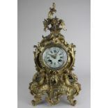 A French gilt metal mantle clock, the circular Roman numeral dial in a Rococo style case, the