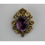 A Victorian gold and foil backed amethyst brooch mounted with the foil backed oval cut amethyst