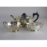 A George V silver three piece tea set oval faceted form to include teapot, sugar bowl and cream jug,