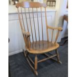 A rocking chair with stick back and solid seat on turned supports and rockers,