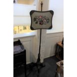 A Victorian rosewood pole screen with glazed needlework panel on tripod base to scroll carved feet