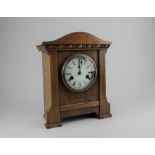 A German mahogany mantle clock, the circular enamel dial with Roman numerals, striking on a gong,