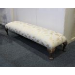 A mahogany long footstool, with rectangular upholstered top on cabriole legs, width 32cm, length