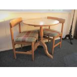 A modern pine circular side table on tripod base together with a pair of bar back dining chairs.