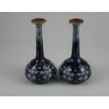 A pair of Royal Doulton stoneware bottle vases by Louisa Wakely, with tube lined floral decoration
