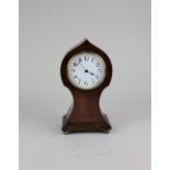 An early 20th century mahogany balloon shaped mantle clock, the circular dial with Arabic