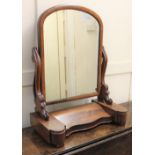 A Victorian mahogany dressing table mirror, the arched mirror in moulded frame, held in carved and