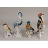Four Karl Ens porcelain models of birds to include a woodpecker 24cm high, and a heron 24cm high (