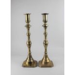 A pair of brass candlesticks baluster shape on cut corner square bases, 43cm