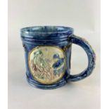 An Edward Bingham Castle Hedingham pottery mug decorated in relief with three roundels for