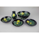 A Moorcroft pottery 'Buttercup' pattern vase, two bowls and two trinket dishes