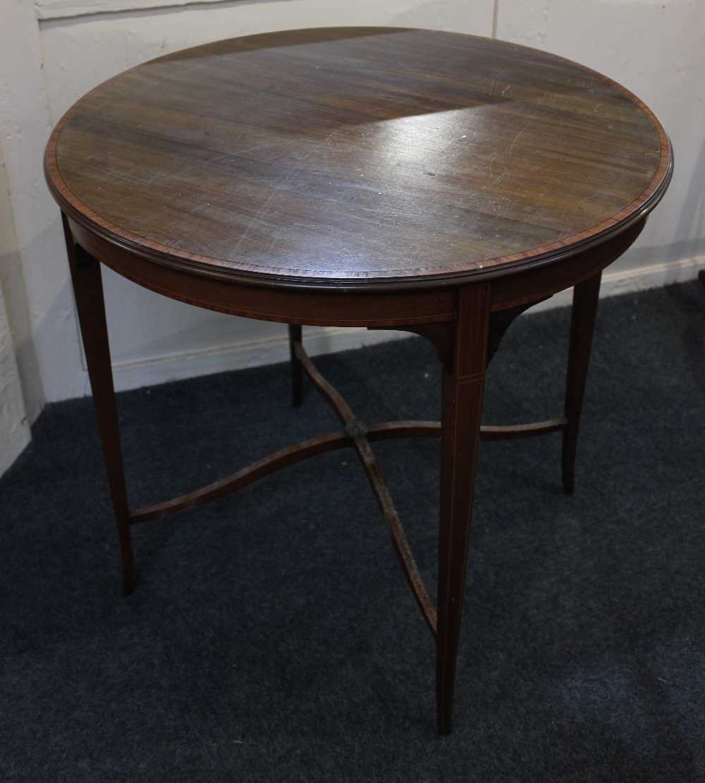 An Edwardian mahogany occasional table, with circular crossbanded top on tapered legs united by X-