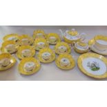 A Victorian porcelain tea set decorated with exotic birds within canary yellow borders with gilt