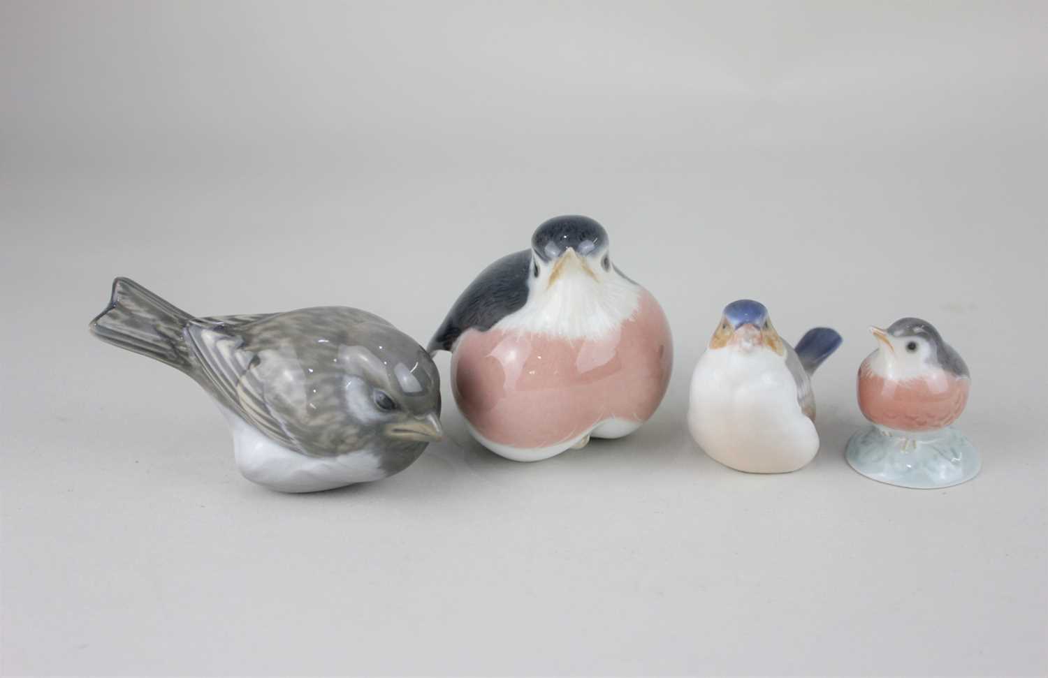 Four Royal Copenhagen porcelain models of birds to include two robins and a sparrow