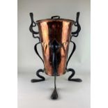An Art Nouveau copper embossed coal box and cover, with wrought iron supports and handle 74cm high