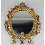 A gilt framed wall mirror, the pierced foliate decorated frame with putti and crown surmount, 38.5cm