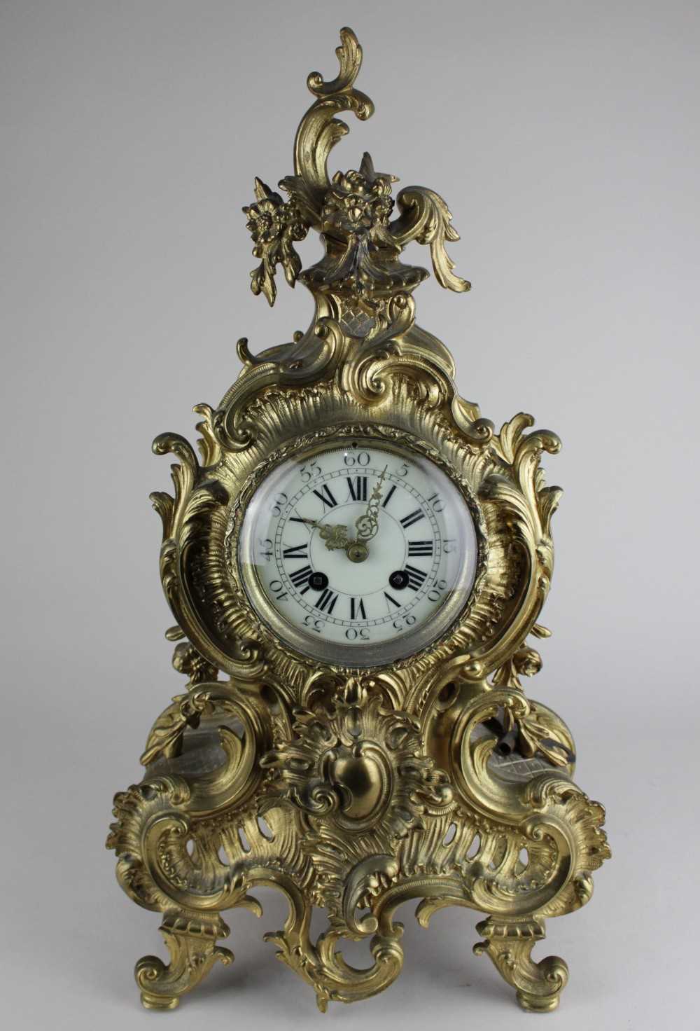 A French gilt metal mantle clock, the circular Roman numeral dial in a Rococo style case, the