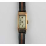 A lady's 9ct gold rectangular cased wristwatch with an unsigned jewelled lever movement, the