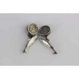 A pair of silver cufflinks, one side modelled as fish, the other side modelled as fishing reels,