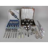 A pair of silver plated grape scissors two pickle forks, sifter spoon, other servers, two cased sets