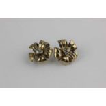 A pair of 9ct gold and diamond ear clips in a cinquefoil design claw set with three central circular