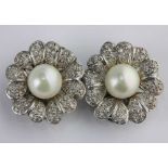 A pair of diamond and cultured pearl ear clips each designed as a flower head centred by a