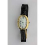 A Cartier 18ct gold curved oval cased manual winding ladies wristwatch, the signed oval dial with