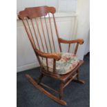 A rocking chair with spindle back and solid seat