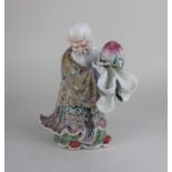 A Chinese porcelain figure of Shou-Lao holding a peach, impressed marks to base 24cm high (a/f)