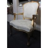 A Louis XV style gilt framed fauteuil armchair with pale yellow upholstery on cabriole legs