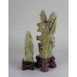 A Chinese carved soapstone figure of a woman holding a vase of flowers 30.5cm high including base,