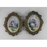 A pair of Sevres style gilt framed oval wall plaques decorated with scenes of lovers, with gilt